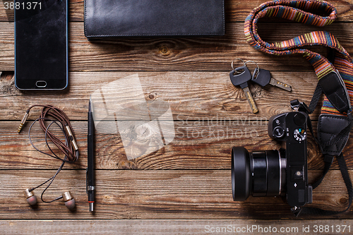 Image of Travel concept - headphones, camera,  sketchbook, purse, pencil and keys on wooden background.
