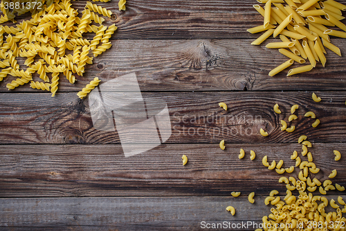 Image of Mixed dried pasta selection on wooden background.