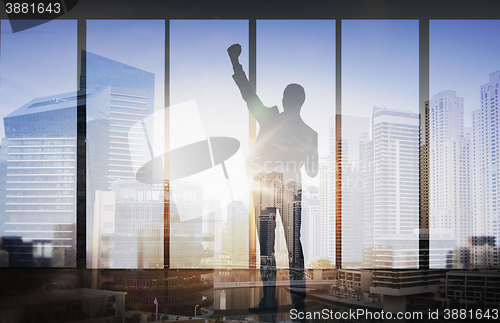 Image of silhouette of business man over city background