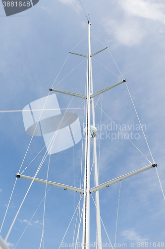 Image of close up of sailboat mast over blue sky