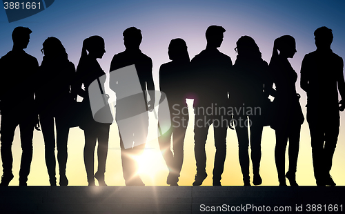 Image of silhouettes of students on stairs over sun