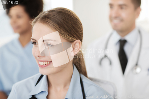 Image of happy doctor over group of medics at hospital