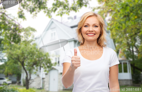Image of smiling woman in white t-shirt showing thumbs up