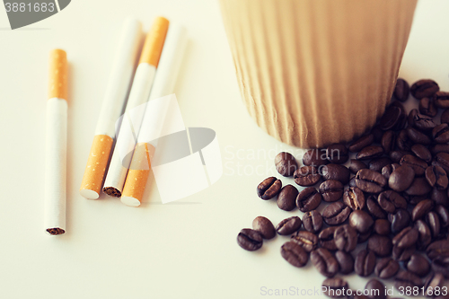 Image of close up of cigarettes, coffee cup and beans