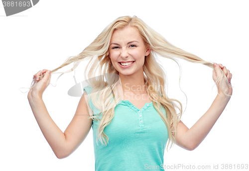 Image of smiling young woman holding strands of her hair