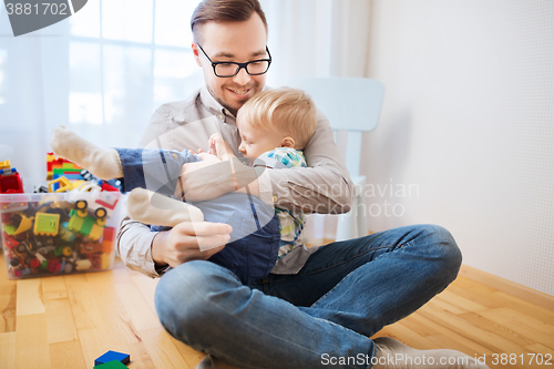 Image of father and son playing and having fun at home