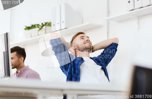 Image of happy creative man with computer at office