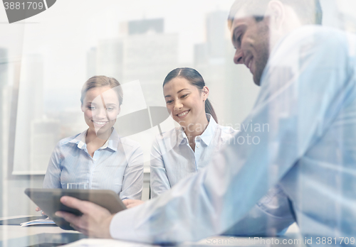 Image of smiling businesspeople with tablet pc in office