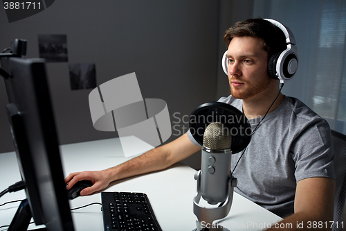 Image of man in headset playing computer video game at home