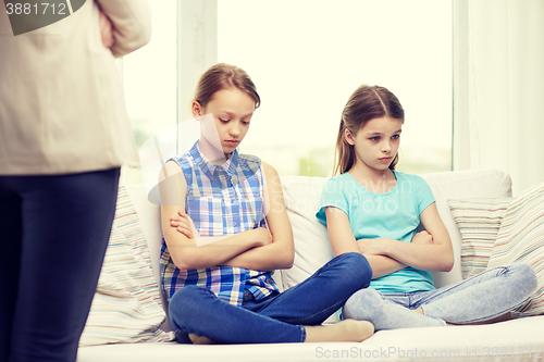 Image of upset guilty little girls sitting on sofa at home