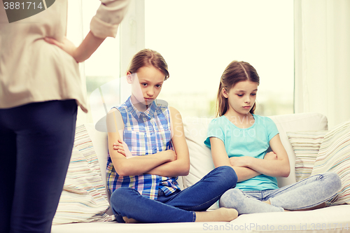 Image of upset guilty little girls sitting on sofa at home