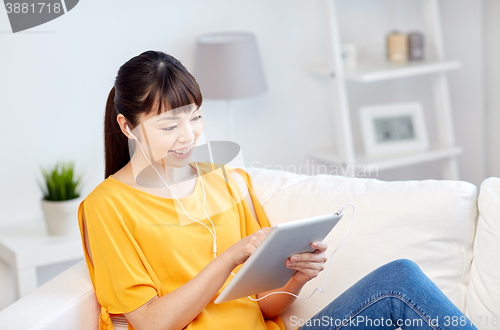 Image of happy asian woman with tablet pc and earphones