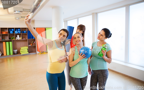 Image of pregnant women taking selfie by smartphone in gym