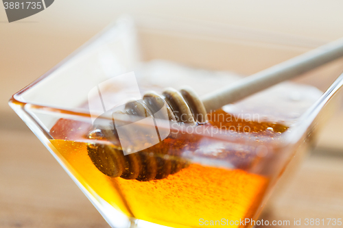 Image of close up of honey in glass bowl and dipper