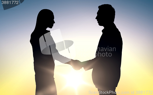 Image of business partners silhouettes shaking hands