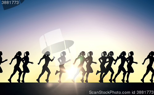 Image of happy young sports woman running outdoors