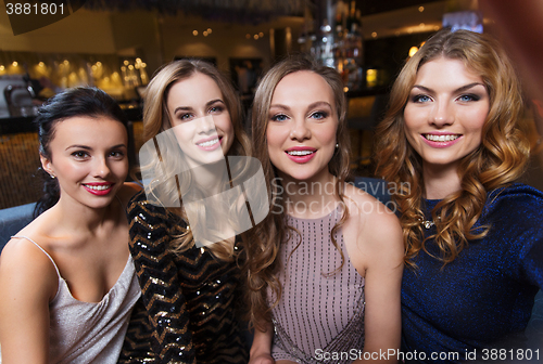 Image of happy smiling women taking selfie at night club