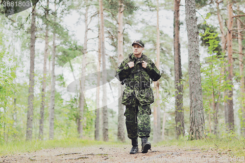 Image of young soldier with backpack in forest