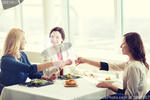 Image of happy women drinking champagne at restaurant