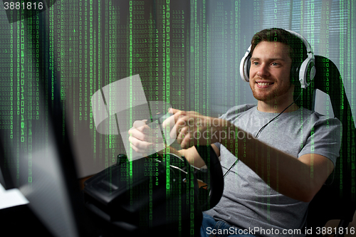 Image of man playing car racing video game at home