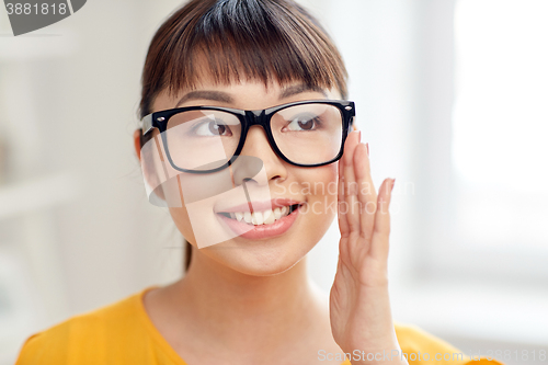 Image of happy asian young woman in glasses at home