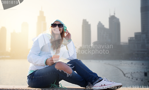 Image of happy young woman with smartphone and headphones