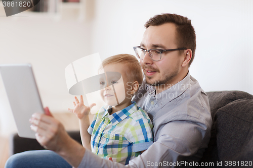 Image of father and son with tablet pc playing at home