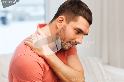 Image of unhappy man suffering from neck pain at home