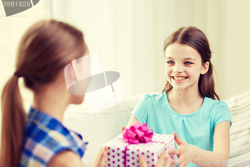 Image of happy little girls with birthday present at home