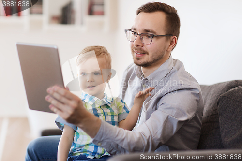 Image of father and son with tablet pc playing at home