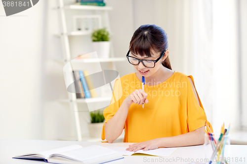 Image of happy asian young woman student learning at home