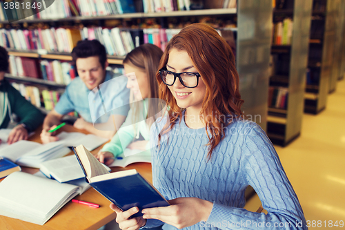 Image of happy students reading books in library