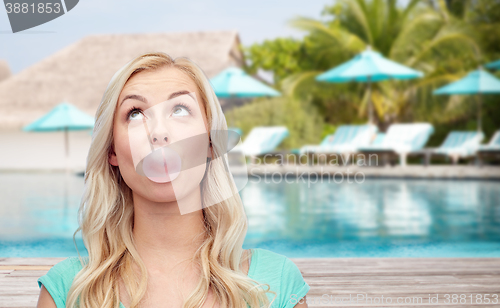 Image of happy woman or teenage girl chewing gum on beach