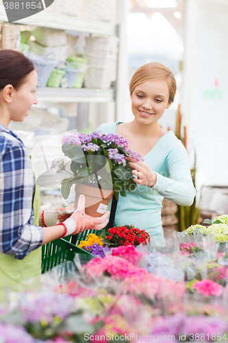 Image of happy women choosing flowers in greenhouse or shop