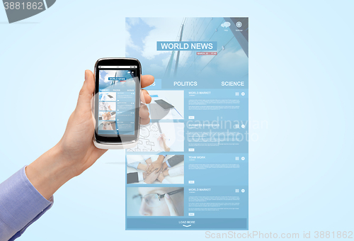 Image of close up of hand with news web page on smartphone