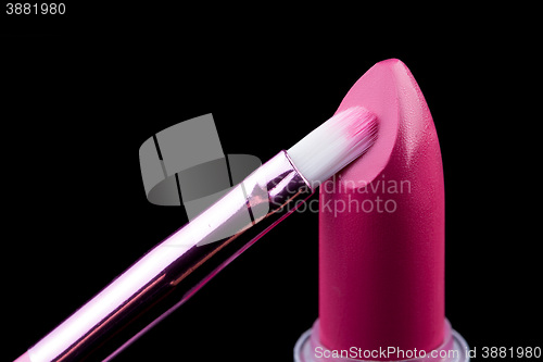 Image of Tube of lipstick with a brush make-up on black 
