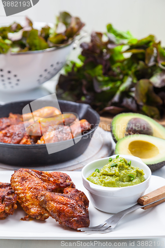 Image of Grilled chicken legs and wings with guacamole