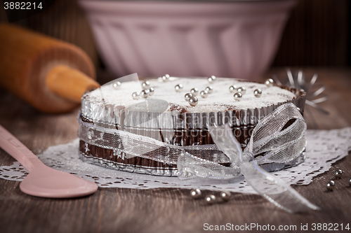 Image of White and chocolate Christmas cake with baking utensils