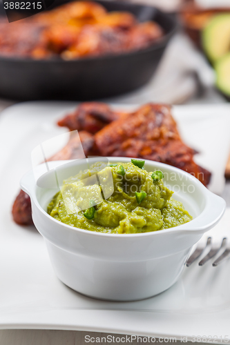 Image of Grilled chicken legs and wings with guacamole