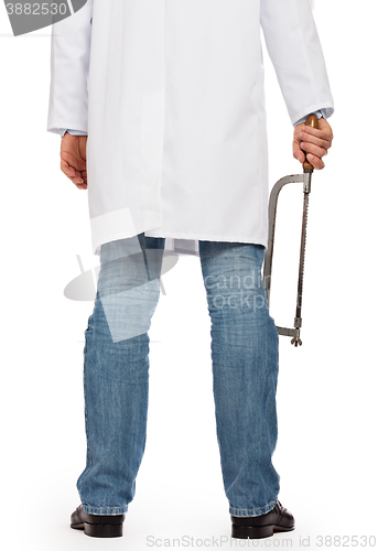 Image of Crazy doctor is holding a big saw in his hands