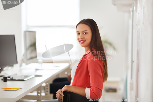 Image of happy african woman with computer at office