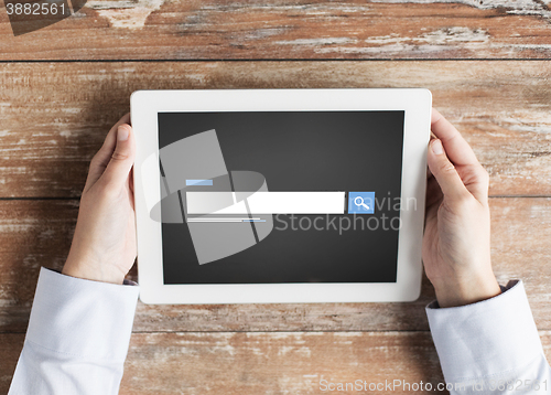 Image of close up of male hands using browser on tablet pc