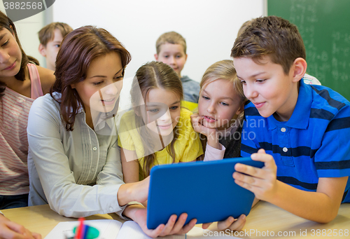 Image of group of kids with teacher and tablet pc at school