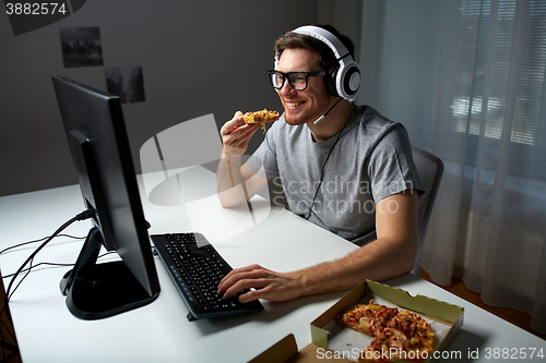 Image of man in headset playing computer video game at home