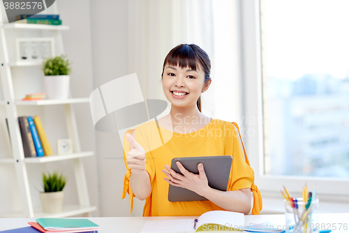 Image of happy asian woman student with tablet pc at home