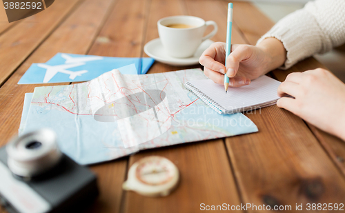 Image of close up of traveler hands with notepad and pencil