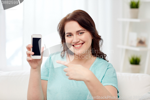 Image of happy plus size woman with smartphone at home