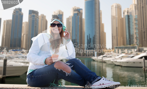 Image of happy young woman with smartphone and headphones