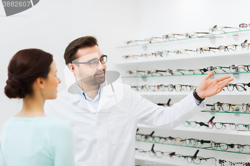 Image of woman and optician showing glasses at optics store