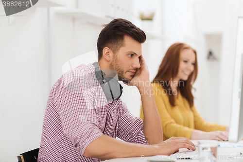 Image of creative team with headphones and computer